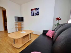 ein Wohnzimmer mit einem schwarzen Sofa und einem Tisch in der Unterkunft Apartment Anđa-4 by Interhome in Trogir
