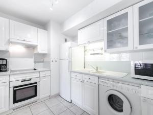 a kitchen with white cabinets and a washing machine at Apartment Côté Port by Interhome in Cavalaire-sur-Mer