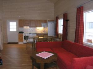 uma sala de estar com um sofá vermelho e uma cozinha em Holiday Home Pernoo 2 by Interhome em Pernoo