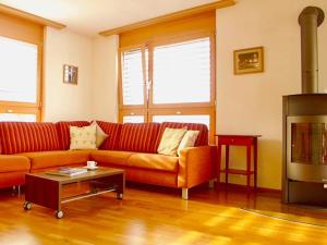 ein Wohnzimmer mit einem roten Sofa und einem Kamin in der Unterkunft Apartment Villa Maria 33 by Interhome in Engelberg