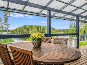 una mesa de madera con un jarrón de flores en la cubierta en Holiday Home Kanervarinne by Interhome, en Lahdenkylä