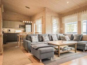 una sala de estar con un sofá y una mesa en Holiday Home Kanervarinne by Interhome, en Lahdenkylä