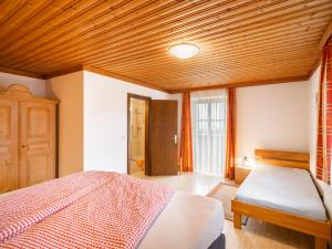 een slaapkamer met een bed en een houten plafond bij Apartment Sommerstein by Interhome in Saalfelden am Steinernen Meer