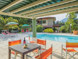 eine Terrasse mit einem Tisch, Stühlen und einem Pool in der Unterkunft Holiday Home Costacce by Interhome in Montemagno