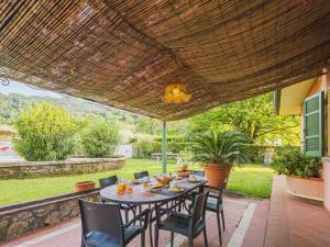 eine Terrasse mit einem Tisch und Stühlen unter einem Dach in der Unterkunft Holiday Home Costacce by Interhome in Montemagno