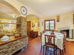 ein Esszimmer mit einem Tisch und einem Steinkamin in der Unterkunft Holiday Home Costacce by Interhome in Montemagno