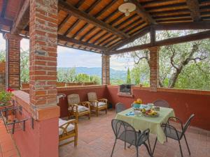 a patio with a table and chairs and a fireplace at Holiday Home Borgo della Limonaia-4 by Interhome in Pieve a Nievole