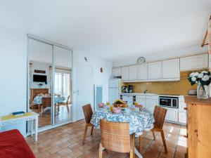 une cuisine et une salle à manger avec une table et des chaises dans l'établissement Apartment Les Sauvagières II-1 by Interhome, à Cavalaire-sur-Mer