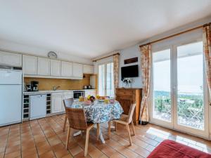 a kitchen with a table and chairs and a kitchen with windows at Apartment Les Sauvagières II-1 by Interhome in Cavalaire-sur-Mer