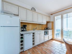 une cuisine avec des appareils blancs et une grande fenêtre dans l'établissement Apartment Les Sauvagières II-1 by Interhome, à Cavalaire-sur-Mer