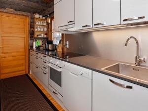 ルカにあるHoliday Home Karhunpesä by Interhomeの白いキャビネットとシンク付きのキッチン