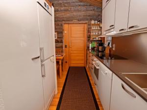 盧卡的住宿－Holiday Home Karhunpesä by Interhome，一间狭窄的厨房,配有白色的橱柜和黑色的地板