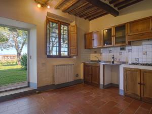 タヴァルネッレ・ヴァル・ディ・ペーザにあるApartment Campiglia-4 by Interhomeのキッチン(木製キャビネット付)、大きな窓が備わります。