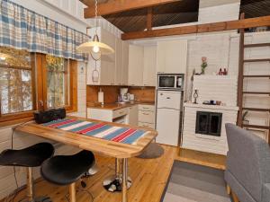 a kitchen with a table and chairs in a room at Holiday Home Kaukosaaren ahonrinne by Interhome in Ruka