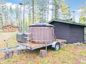 a large wooden appliance sitting on a trailer next to a building at Holiday Home Koskimökki by Interhome in Kortteinen