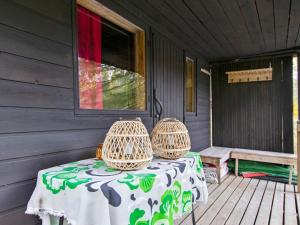 una mesa en un porche con dos jaulas de pájaro en Holiday Home Koskimökki by Interhome, en Kortteinen