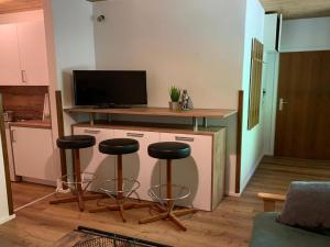 ein Wohnzimmer mit 2 Barhockern und einem TV in der Unterkunft Apartment Top 49A by Interhome in Heiligenblut