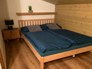 Bett mit blauer Decke in einem Zimmer in der Unterkunft Apartment Top 49A by Interhome in Heiligenblut