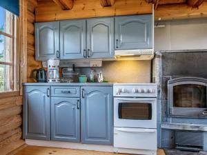 kuchnia z niebieskimi szafkami i piekarnikiem w obiekcie Holiday Home Hirvonmökki by Interhome w mieście Kurkimaki