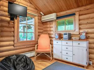 Pokój z krzesłem i telewizorem w drewnianej kabinie w obiekcie Holiday Home Hirvonmökki by Interhome w mieście Kurkimaki