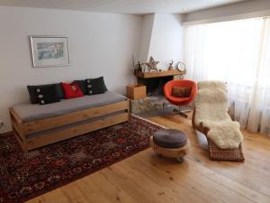 ein Wohnzimmer mit einem Sofa und einem Stuhl in der Unterkunft Apartment Casa Rustica by Interhome in Lenzerheide