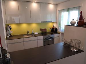 a kitchen with white cabinets and a black counter top at Apartment Rustica by Interhome in Lenzerheide