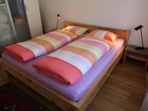 two beds with colorful pillows on top of them at Apartment Rustica by Interhome in Lenzerheide +13 photos