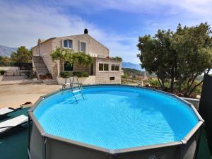 a large swimming pool in front of a house at Holiday Home Ivana by Interhome in Selca