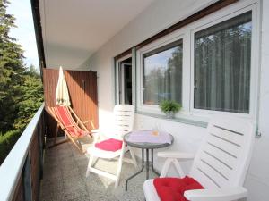 a balcony with two chairs and a table and two windows at Apartment Am Birkenhain-19 by Interhome in Seefeld in Tirol