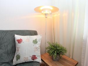 a lamp sitting next to a couch with a pillow at Apartment Am Birkenhain-19 by Interhome in Seefeld in Tirol