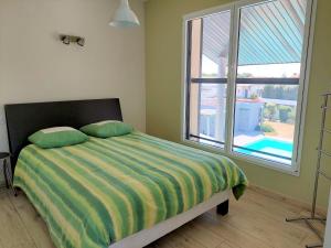 um quarto com uma cama e uma grande janela em Apartment Les Epinettes by Interhome em Saint-Gilles-Croix-de-Vie