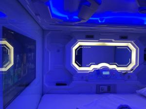 a room with a bed with a blue light at BMAX SPACEPODS in Pusok
