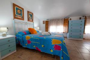 希梅拉德利瓦爾的住宿－Encantadora casa de pueblo para 7 pax con gran Terraza，一间卧室配有一张带蓝色棉被的床