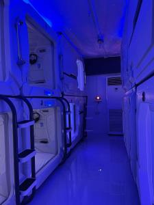 an empty room with blue lights in a room at BMAX SPACEPODS in Pusok