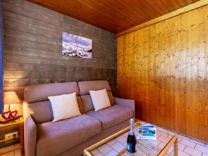 Apartment Super Tignes-2 by Interhome في تينيِ: غرفة معيشة مع أريكة في جدار خشبي