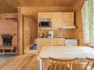 LahdenkyläにあるHoliday Home Kinturi by Interhomeのキッチン(木製キャビネット、テーブル、椅子付)