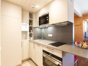ティーニュにあるApartment Grand Roc - Val Claret-1 by Interhomeの白いキャビネットとシンク付きのキッチン