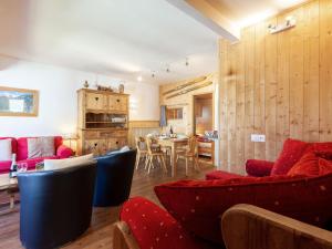 a living room with red and blue chairs and a table at Apartment Grand Roc - Val Claret-1 by Interhome in Tignes +17 photos
