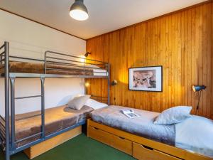 ティーニュにあるApartment Le Pramecou-15 by Interhomeの木製の壁の客室で、二段ベッド2組が備わります。