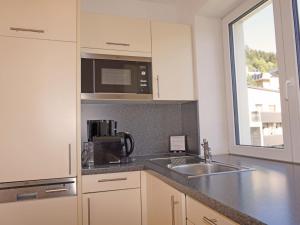 a kitchen with a sink and a microwave at Apartment Ladis-10 by Interhome in Ladis