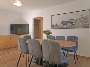 a dining room with a table and chairs and a television at Apartment Ladis-10 by Interhome in Ladis