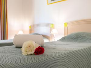 een rode en witte roos bovenop een bed bij Apartment Les Calanques du Parc-3 by Interhome in Saint-Aygulf