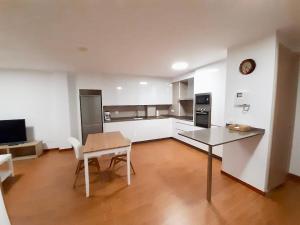馬爾皮卡的住宿－Cómodo apartamento en la costa Gallega，一间带桌子的客厅和一间厨房