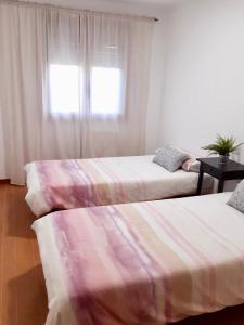 馬爾皮卡的住宿－Cómodo apartamento en la costa Gallega，带窗户的客房内的两张床