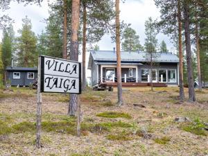 a sign in front of a house in the woods at Holiday Home Villa taiga by Interhome in Ylikyro