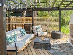 a patio with a couch and chairs on a wooden deck at Holiday Home Villa saimaan joutsenlahti by Interhome in Äitsaari