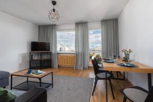 a living room with a table and chairs and a room with a window at Salt Island Apartment Sea and Harbor View by Renters in Kołobrzeg