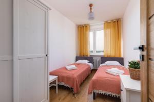 two beds in a room with a window at Salt Island Apartment Sea and Harbor View by Renters in Kołobrzeg