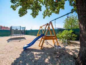 a playground with a slide next to a tree at Holiday Home Villa Maria by Interhome in Donji Proložac