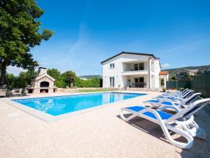 a villa with a swimming pool and lounge chairs at Holiday Home Villa Maria by Interhome in Donji Proložac